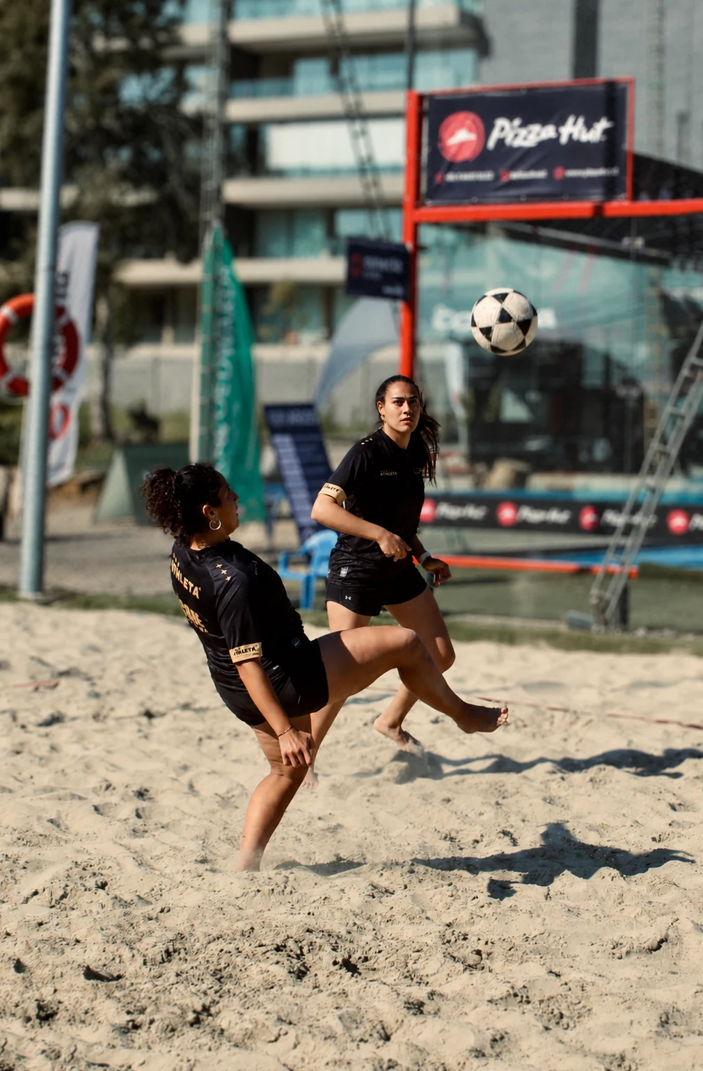 Jugadoras disputando un punto de Footvolley sobre arena
