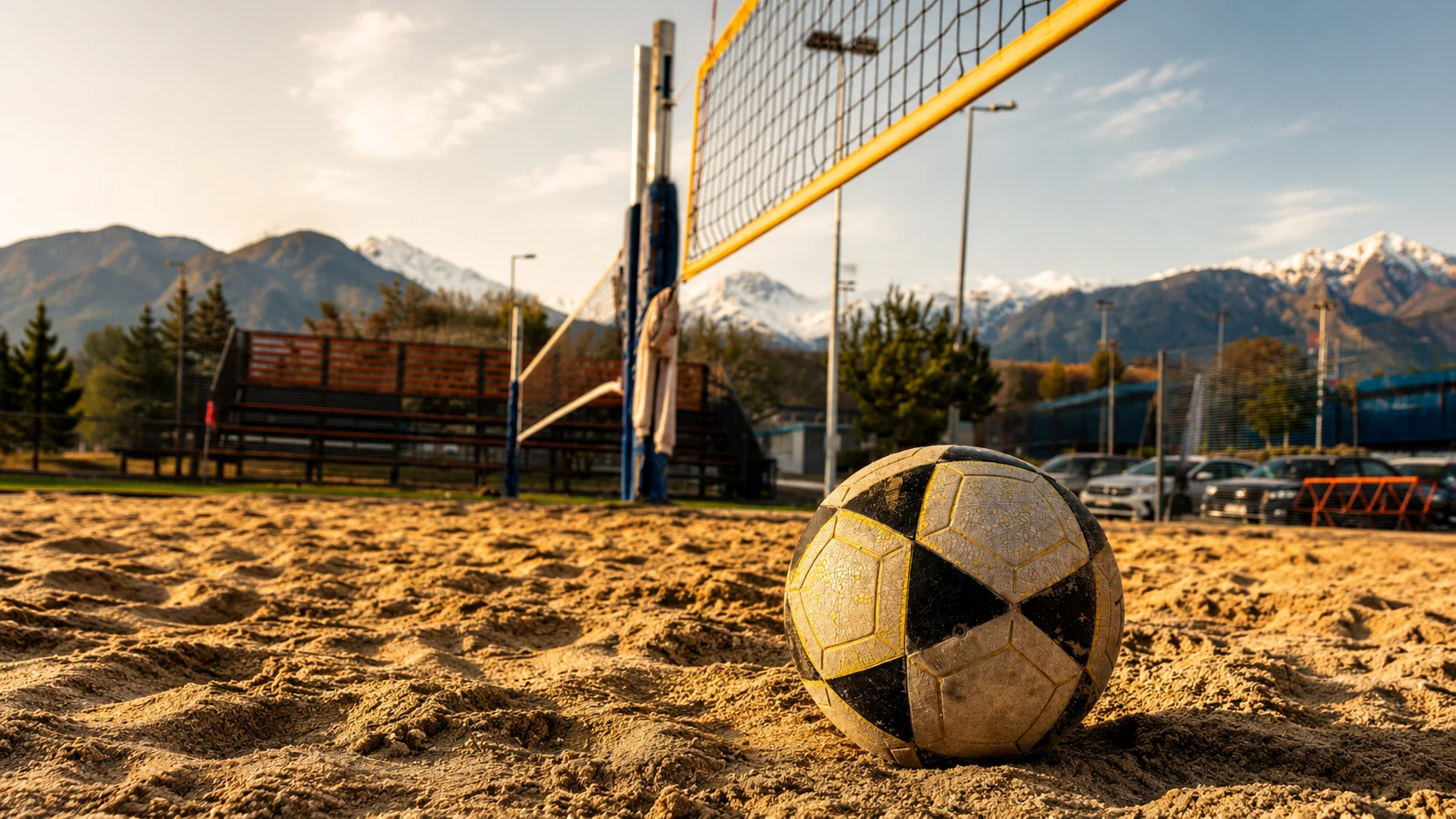 Balón de Footvolley sobre la arena con una cancha y la cordillera al fondo